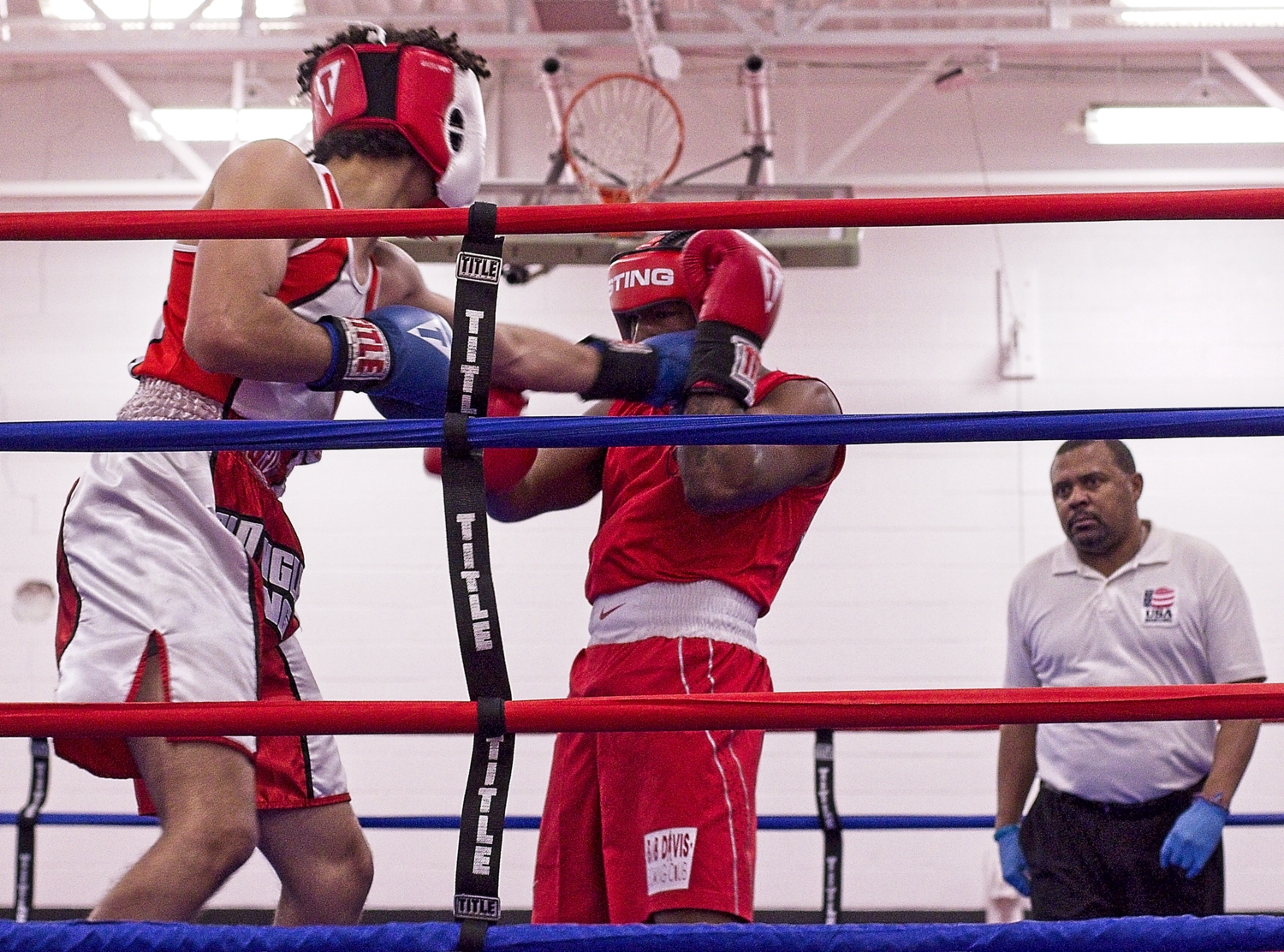 Referee stands off to the right while two boxers spar
